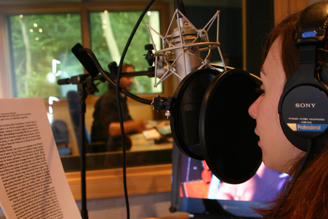 Cabine de studio d’enregistrement avec une artiste de voix féminine lisant