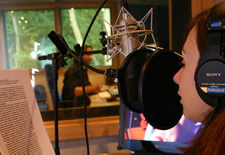 Studio booth at PrimeVoices with female voice artist reading
